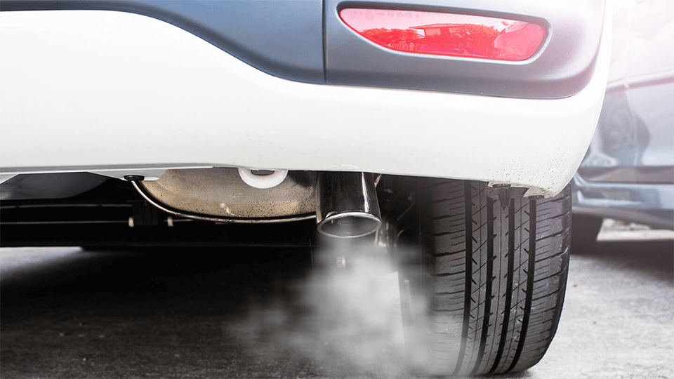 The back of a car with exhaust coming out from the muffler